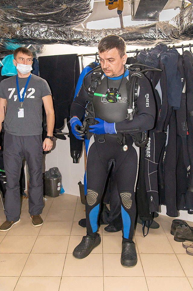 На ногах Алексея Суханкина специальная обувь, в которой водолазы могут ходить в океанариуме